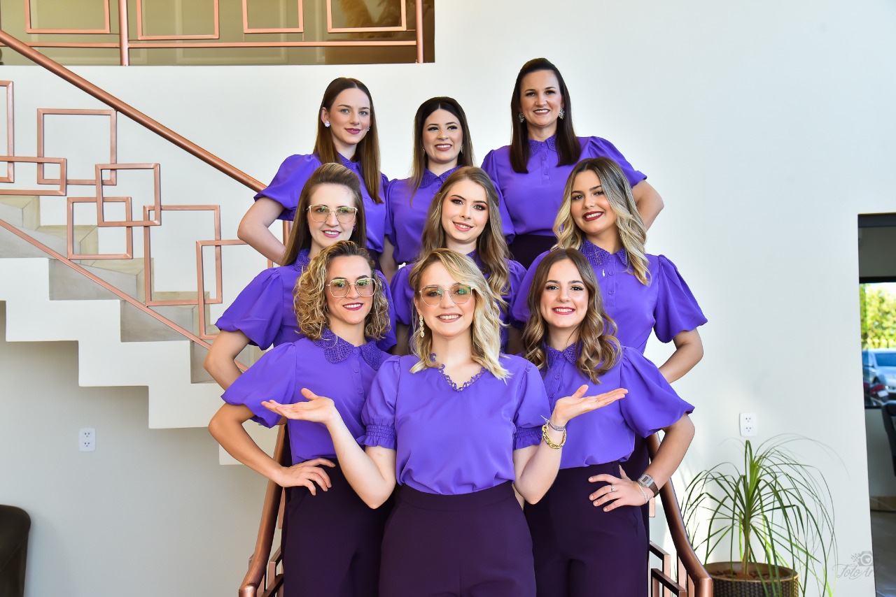 El equipo de LK reunido en la escalera del salón con sus uniformes violeta